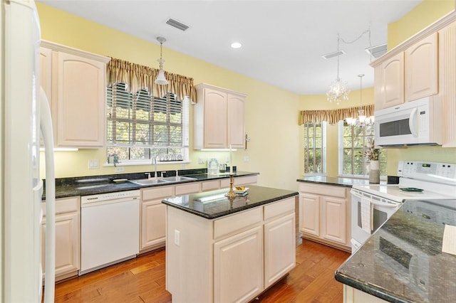 kitchen with hanging light fixtures, white appliances, a notable chandelier, and sink