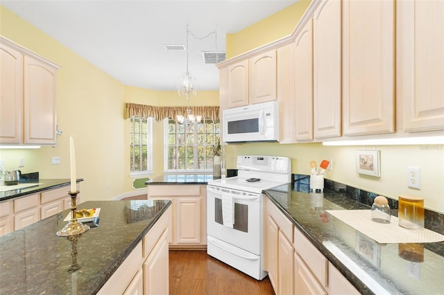 kitchen featuring pendant lighting, white appliances, a chandelier, and dark stone countertops