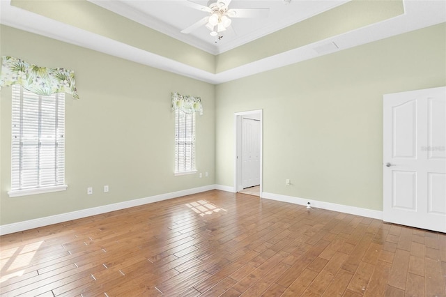 unfurnished room with a tray ceiling, light hardwood / wood-style flooring, and ceiling fan