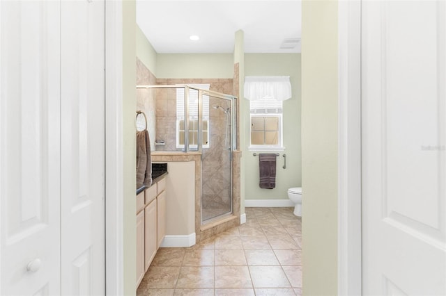 bathroom featuring walk in shower, toilet, and tile patterned flooring