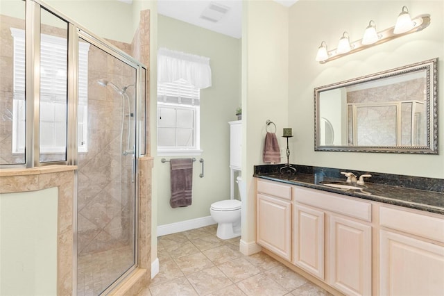 bathroom featuring vanity, tile patterned floors, toilet, and walk in shower