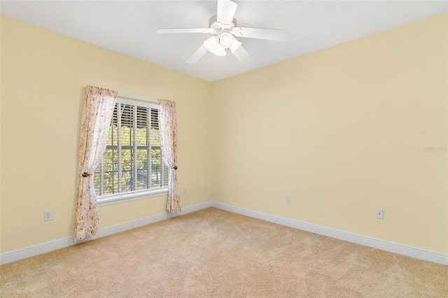 carpeted spare room featuring ceiling fan