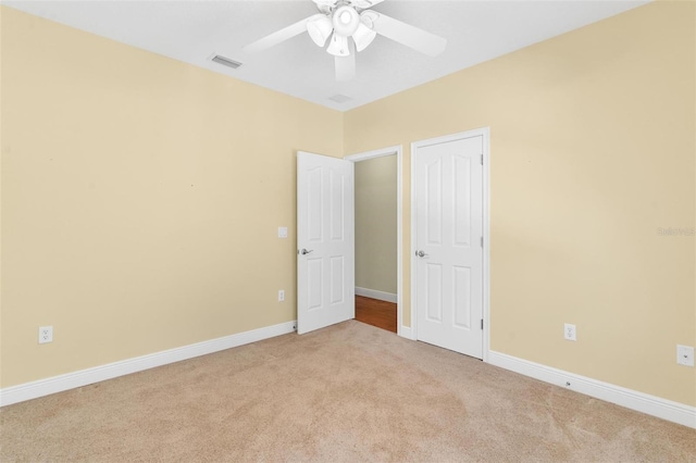 unfurnished bedroom featuring light colored carpet and ceiling fan