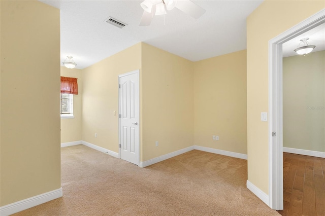 unfurnished room featuring ceiling fan and light carpet