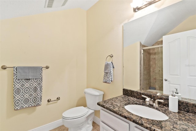 bathroom with vanity, lofted ceiling, toilet, and walk in shower