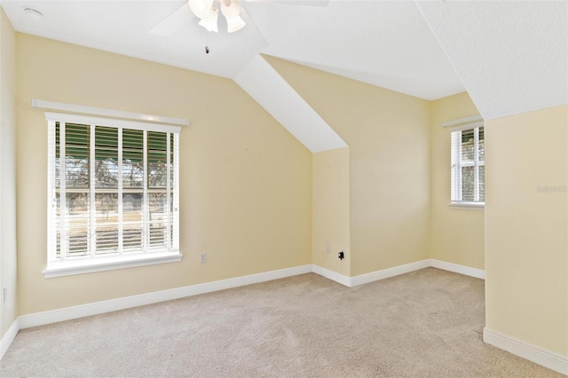 bonus room with a healthy amount of sunlight, vaulted ceiling, and light carpet