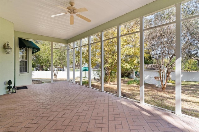 unfurnished sunroom with ceiling fan