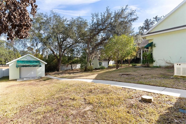 view of yard featuring a garage and an outbuilding