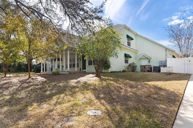 rear view of property featuring a porch, a yard, and central air condition unit