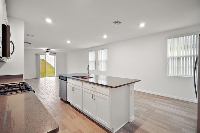 kitchen featuring white cabinets, a center island with sink, sink, ceiling fan, and stainless steel appliances