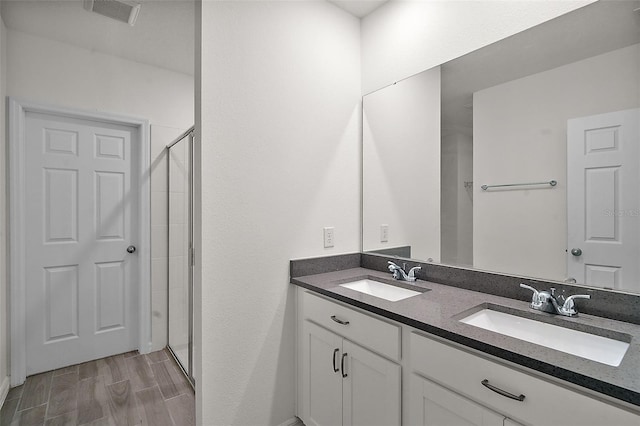 bathroom with vanity and a shower with shower door