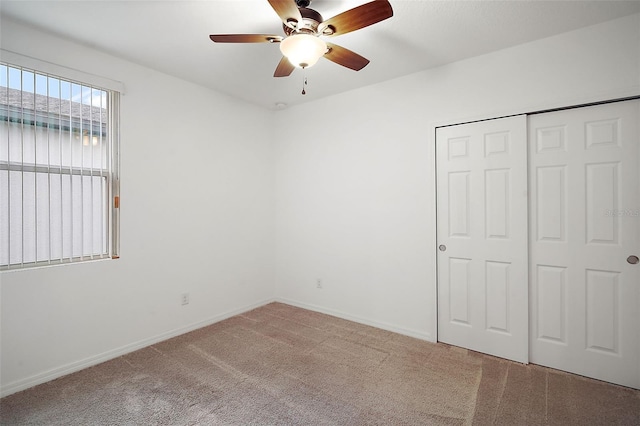 unfurnished bedroom featuring ceiling fan, a closet, and light carpet