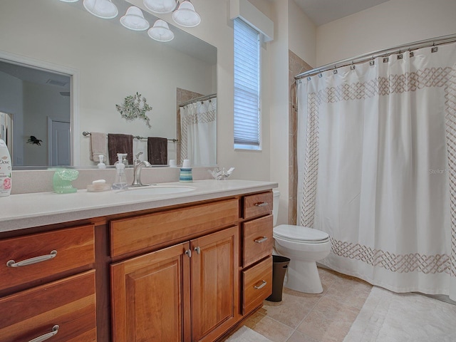 bathroom with toilet, a wealth of natural light, tile patterned flooring, and vanity