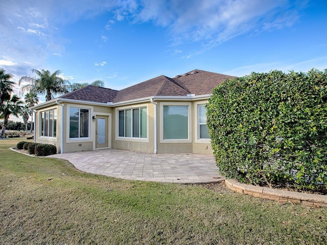 rear view of property featuring a lawn and a patio