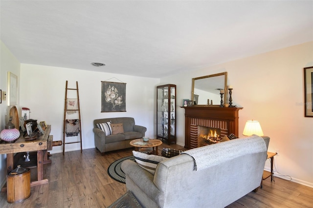 living room with wood-type flooring and a brick fireplace