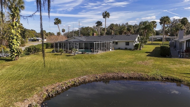 rear view of property featuring a water view, glass enclosure, and a lawn