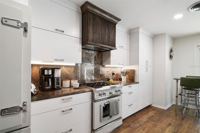 kitchen featuring backsplash, fridge, dark wood-type flooring, high end stainless steel range, and dark brown cabinets