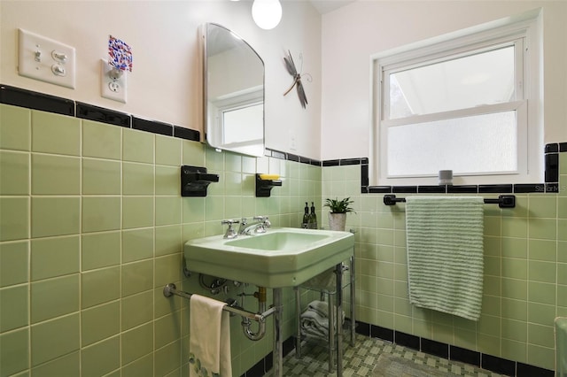 bathroom featuring sink and tile walls