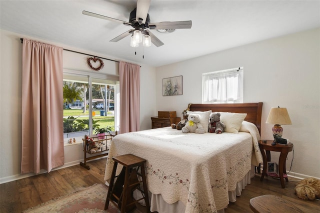 bedroom featuring dark wood-type flooring, ceiling fan, and multiple windows