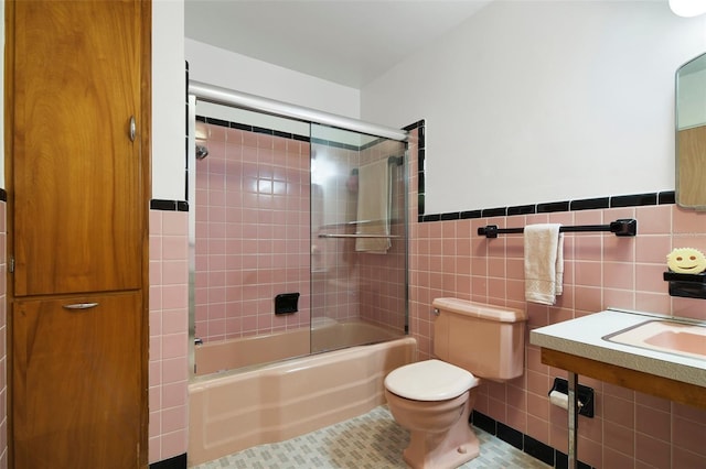 bathroom featuring tiled shower / bath, tile patterned floors, toilet, and tile walls