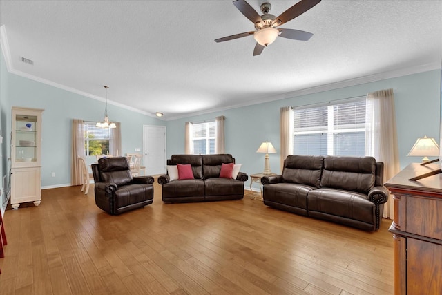 living room featuring lofted ceiling, ceiling fan, plenty of natural light, and ornamental molding