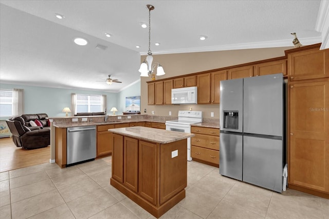 kitchen with a kitchen island, ornamental molding, stainless steel appliances, and vaulted ceiling