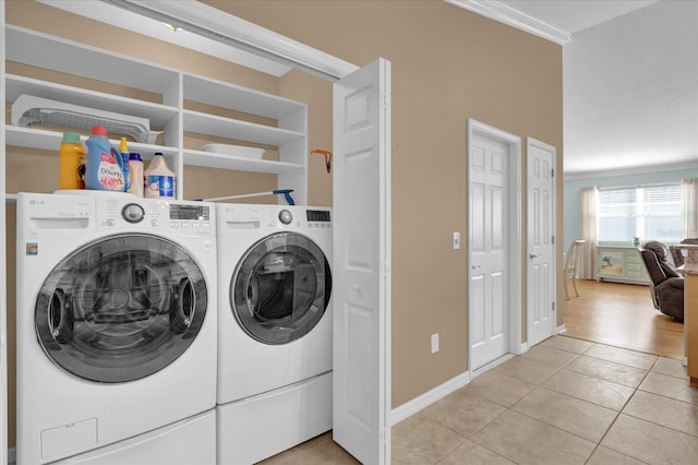 laundry room featuring light tile patterned floors, ornamental molding, and separate washer and dryer