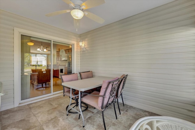 dining space with ceiling fan with notable chandelier