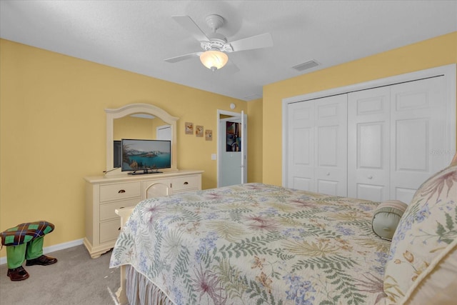 bedroom featuring a closet, light colored carpet, and ceiling fan