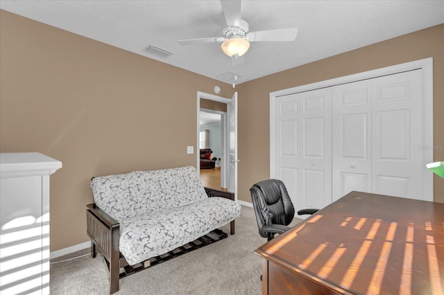 carpeted home office featuring ceiling fan