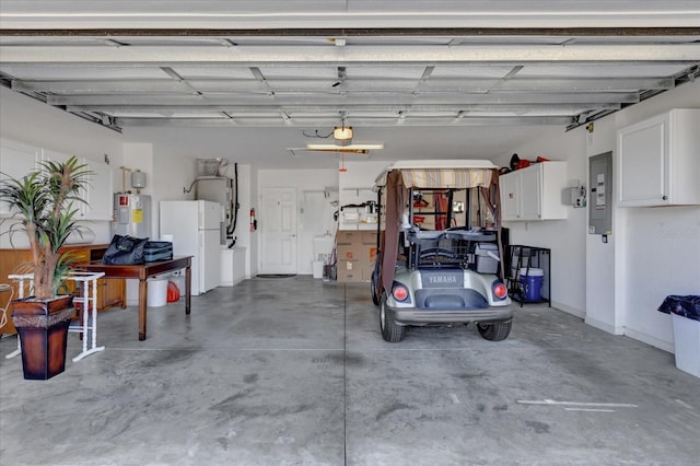 garage featuring electric panel, electric water heater, and white refrigerator