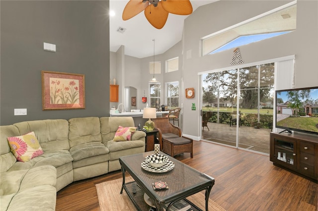 living room featuring high vaulted ceiling, hardwood / wood-style floors, ceiling fan, and a healthy amount of sunlight