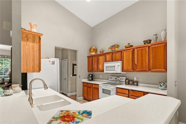 kitchen with white appliances, kitchen peninsula, high vaulted ceiling, and sink