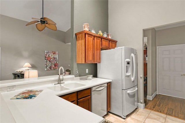 kitchen with sink, light tile patterned flooring, ceiling fan, stainless steel dishwasher, and white fridge with ice dispenser