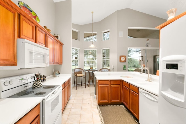 kitchen featuring white appliances, vaulted ceiling, sink, decorative light fixtures, and light tile patterned flooring