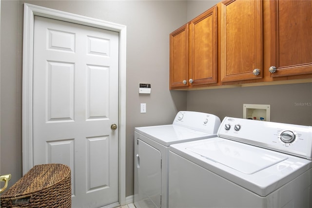 washroom with cabinets and washing machine and clothes dryer