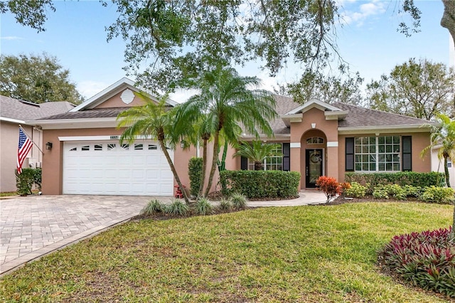 ranch-style home featuring a garage and a front lawn