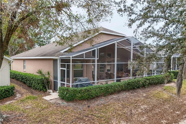 rear view of house featuring glass enclosure