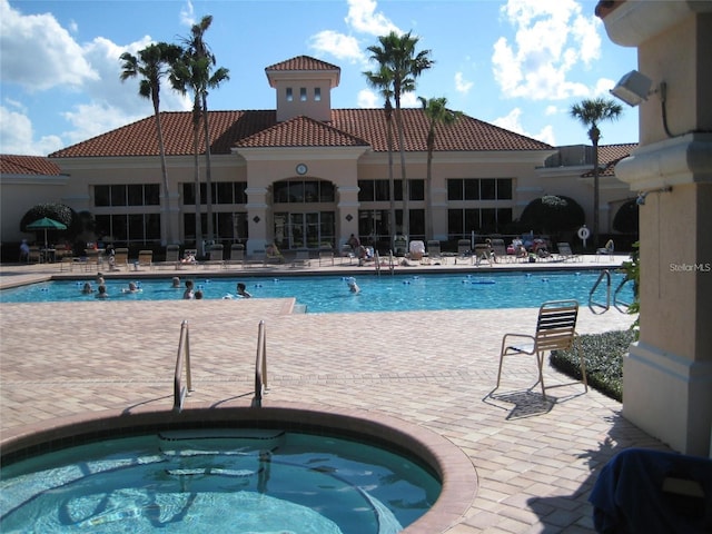 view of swimming pool featuring a community hot tub and a patio