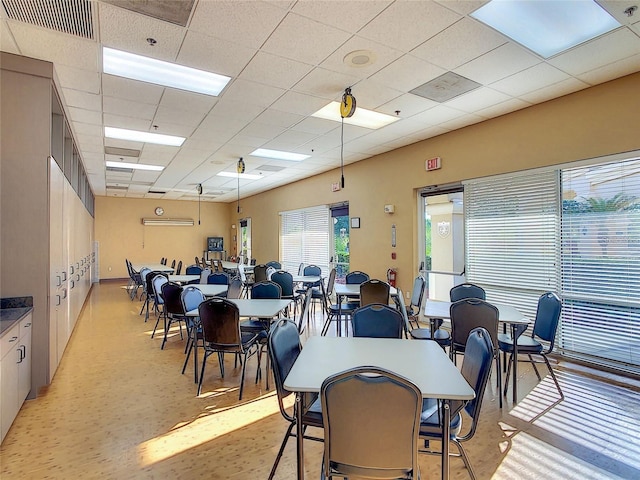 carpeted dining area featuring a paneled ceiling