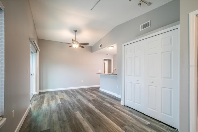 unfurnished living room featuring dark wood-type flooring, ceiling fan, and lofted ceiling