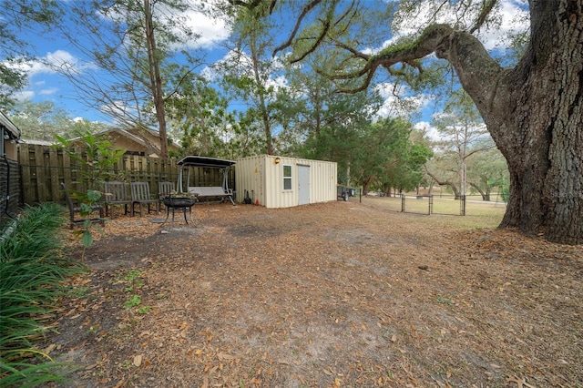 view of yard with a storage shed, fence, and an outbuilding