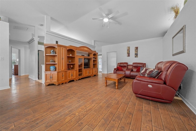 living area with hardwood / wood-style floors, a ceiling fan, and baseboards