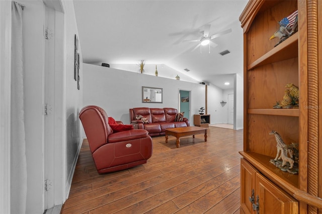 living room with lofted ceiling, wood-type flooring, visible vents, a ceiling fan, and baseboards