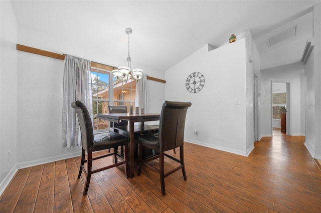 dining area with a chandelier, lofted ceiling, dark wood-style flooring, and visible vents