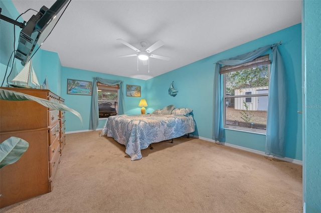 bedroom with ceiling fan, baseboards, and carpet flooring