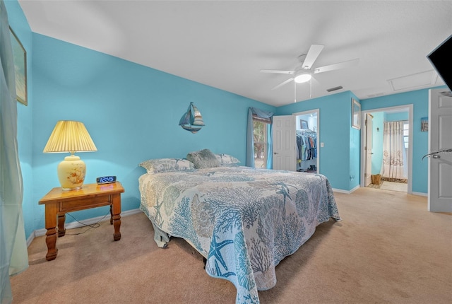 carpeted bedroom featuring attic access, baseboards, ceiling fan, a spacious closet, and a closet