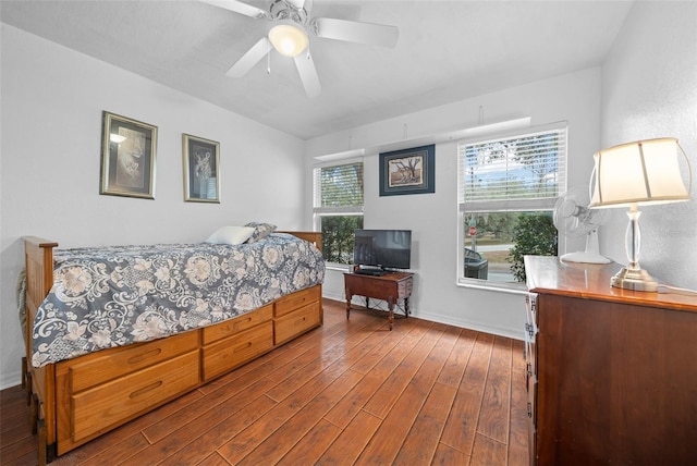 bedroom with dark wood-style floors, ceiling fan, and baseboards