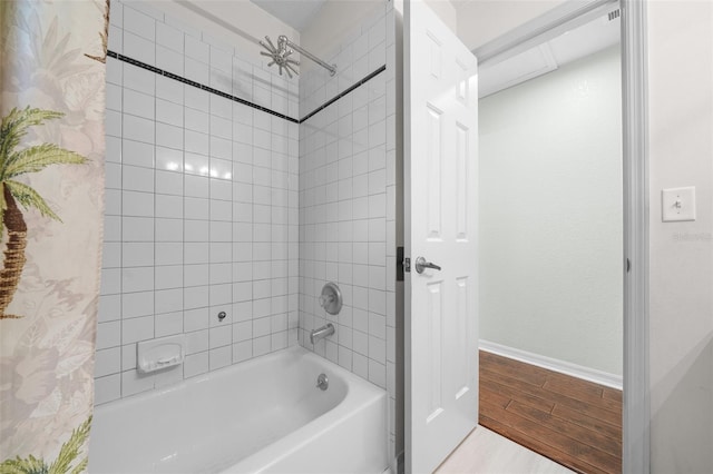 full bathroom with wood finish floors, bathtub / shower combination, and baseboards