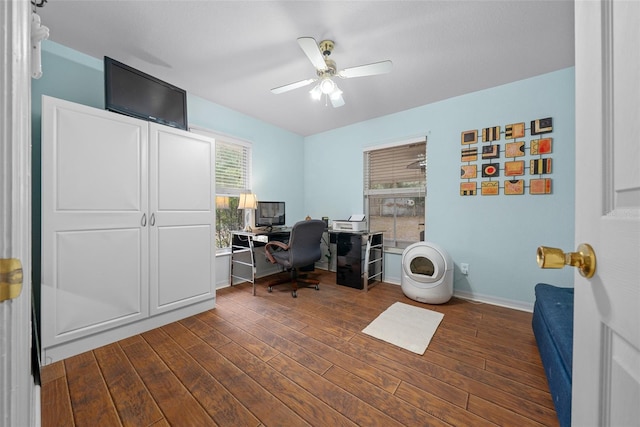 office space with dark wood-style floors, a ceiling fan, and baseboards